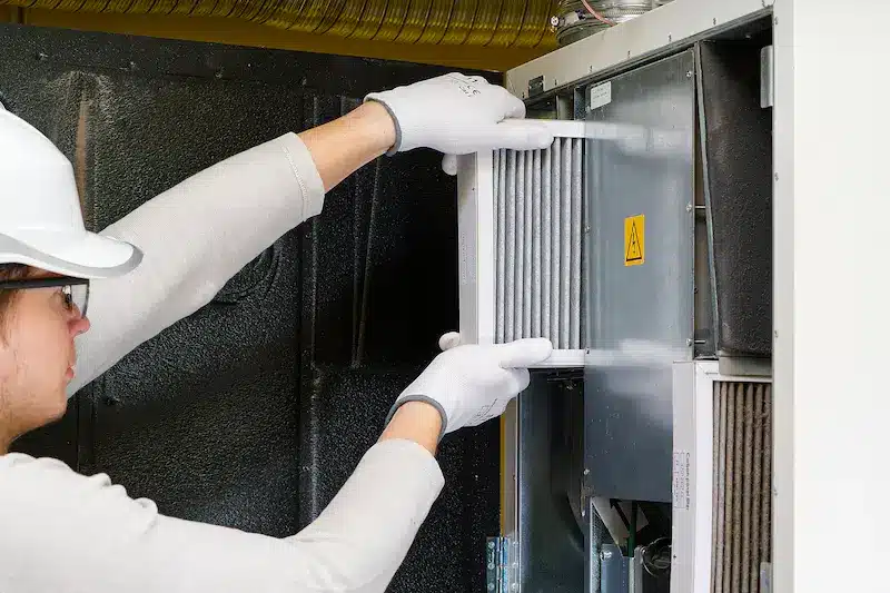 hvac tech showing how often to change your HVAC filter.